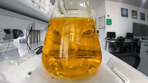 Yellow liquid inside a flask at a supplement laboratory Stock Footage 101217930