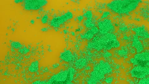 Yellow Liquid Surface with Shapeless Glitter Patterns, Glitter Paints on Water,  Video stock 169932350