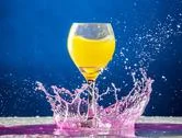 Yellow Liquid In A Wine Glass Fall Onto Pink Liquid Splashing On A Table Stock Photos