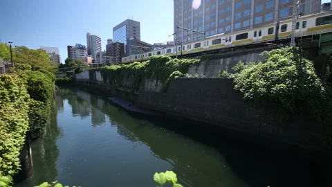 Yellow local train run through the city of Tokyo. Dolly right. Stock Footage 220095427
