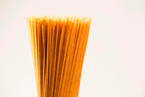 Yellow long spaghetti integral on a rustic background. Yellow italian pasta. Stock Photos