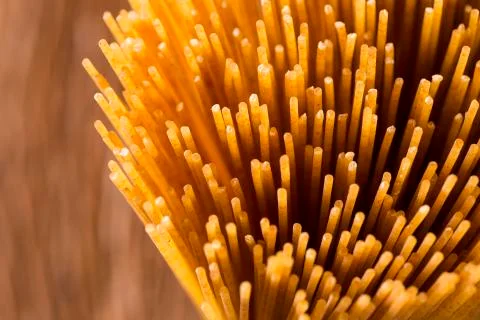 Yellow long spaghetti integral on a rustic background. Yellow italian pasta. Stock Photos