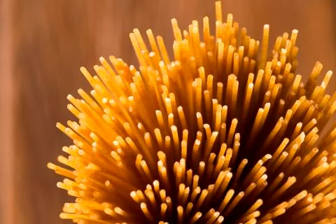 Yellow long spaghetti integral on a rustic background. Yellow italian pasta. Stock Photos
