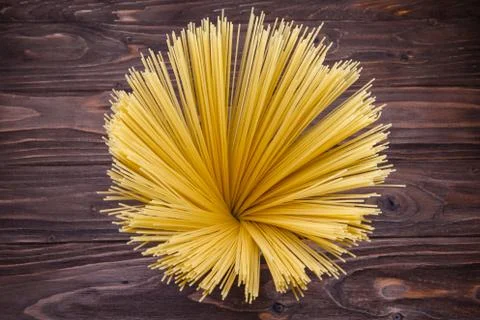 Yellow long spaghetti on a rustic background Stock Photos