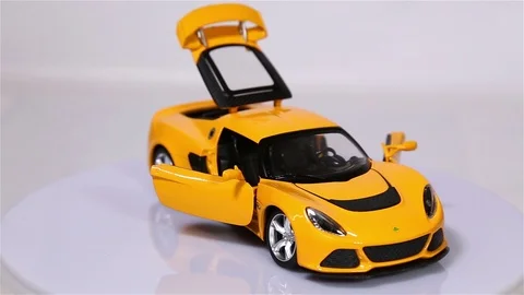 Yellow Lotus Exiges scale model sports car with opened doors is rotating Video stock 101774021