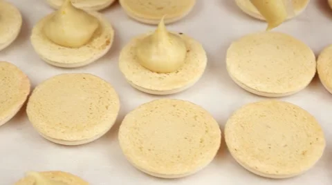 Yellow Macarons halves coated with cream, slow motion Stock Footage 62426301