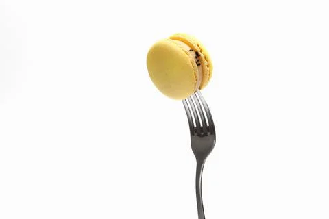 Yellow macaroons on a fork, top view. Sweet french macaroons cake isolated .. Stock Photos