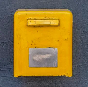 Yellow mail box on the wall Stock Photos