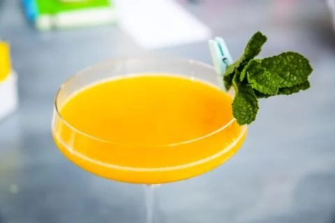 Yellow mango cocktail with mint leaf in a glass. Stock Photos