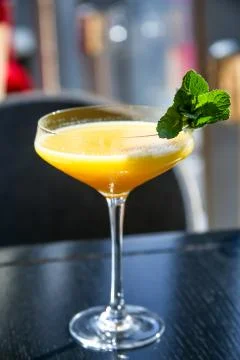 Yellow mango cocktail with mint leaf in a glass. Stock Photos