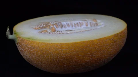 Yellow melon on a black background, close up. Rotates half yellow melon Stock Footage 94344070