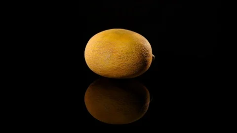 Yellow melon on a black background rotates, close up Stock Footage 79136182