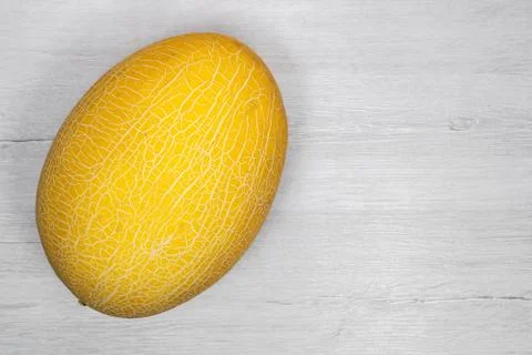 Yellow melon.Yellow melon on a background of bleached wood. Stock Photos
