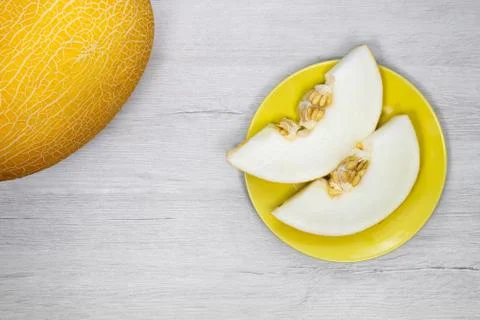 Yellow melon.Yellow melon on a background of bleached wood. Stock Photos