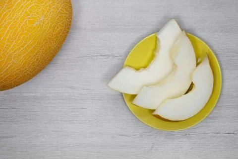Yellow melon.Yellow melon on a background of bleached wood. Stock Photos