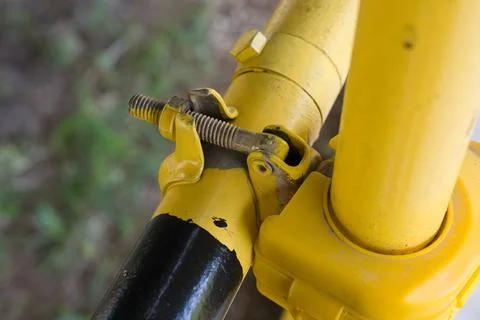 Yellow metal pipe joint with rusty bolt Stock Photos