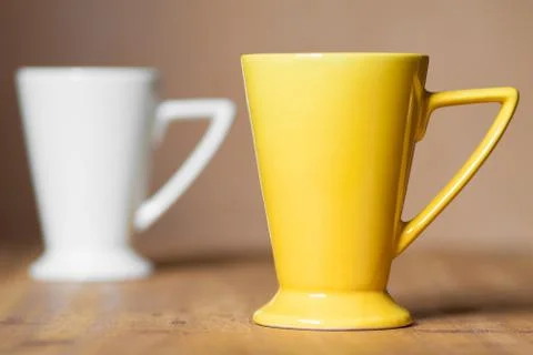 Yellow mug on the desktop Stock Photos