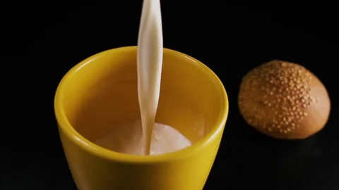 The yellow mug is filled with milk. Slow mo Stock Footage 75267799