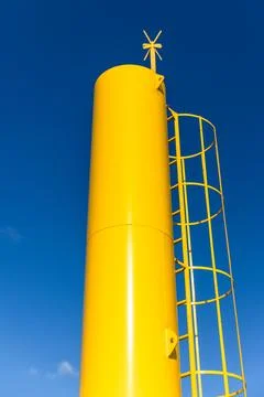 Yellow navigation tower with cross shaped top mark Stock Photos