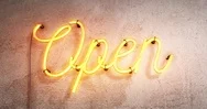 Yellow Neon Sign Saying The Word Open On A Grey Concrete Wall Background, Stock Footage