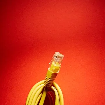 Yellow network cable on red background Stock-Fotos