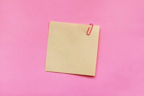Yellow note paper label with clip on pink background Stock Photos