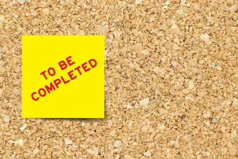 Yellow note paper with word to be completed on cork board background with c.. Stock Photos