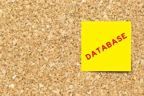 Yellow note paper with word database on cork board background with copy space 写真素材