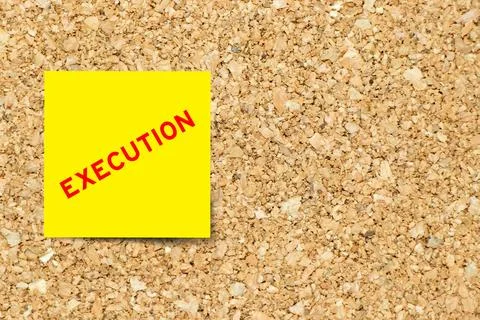 Yellow note paper with word execution on cork board background with copy spac Stockfoto's