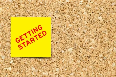 Yellow note paper with word getting started on cork board background with c.. 스톡 사진