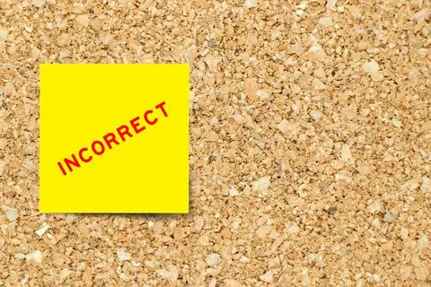 Yellow note paper with word incorrect on cork board background with copy spac Foto stock