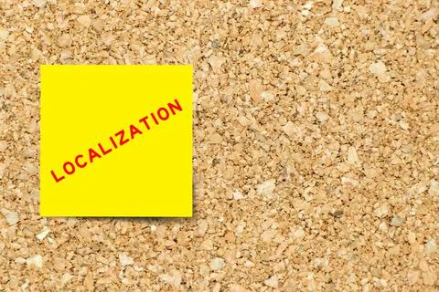 Yellow note paper with word localization on cork board background with copy s Stock Photos