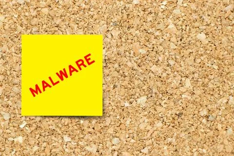 Yellow note paper with word malware on cork board background with copy space Stock Photos
