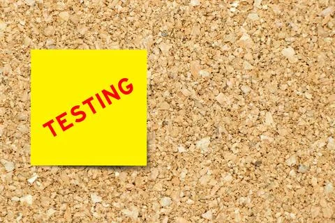 Yellow note paper with word testing on cork board background with copy space Stock Photos