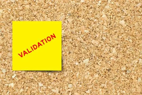 Yellow note paper with word validation on cork board background with copy spa Stock Photos