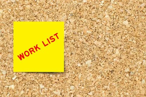 Yellow note paper with word work list on cork board background with copy spac Foto stock