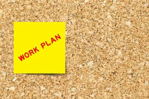 Yellow note paper with word work plan on cork board background with copy spac Stock Photos