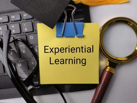 A yellow note reading Experiential Learning is clipped to a keyboard beside.. Stock Photos