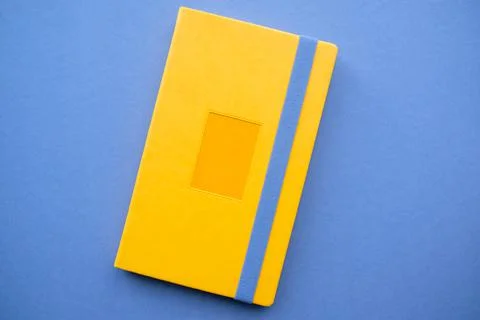 Yellow notepad on a gray background. Bright book with an elastic band Stock Photos