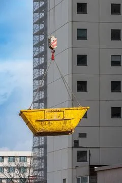 Yellow old skip bin hanging on chains Stock Photos