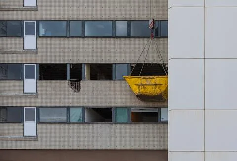 Yellow old skip bin hanging on chains Stock Photos