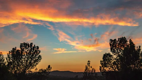 Yellow Orange Red Sunset Floats Behind Foothill Forest Stock Footage 281379952