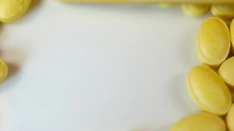 Yellow oval pressed tablets without shell shift up Real time, copyspace, natural Stock Footage 144855359