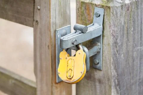 Yellow padlock on a closed gates Stock Photos