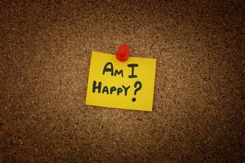 A yellow paper note with the question Am I Happy on it pinned to a cork board Stock Photos
