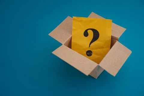 Yellow paper note with question mark inside an open cardboard box Stock Photos