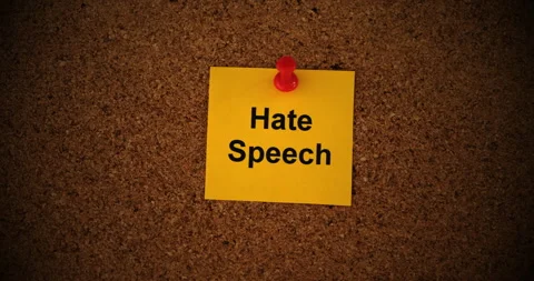 A yellow paper note with the words Hate Speech on it pinned to a cork board Stock Footage 255680983