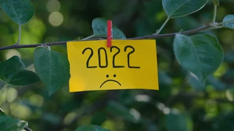A yellow paper note with the year 2022 and a sad face on it Stock Footage 219259497