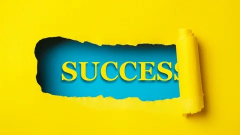 Yellow paper is torn over blue background with word "success", stop motion. Stock Footage 121189464