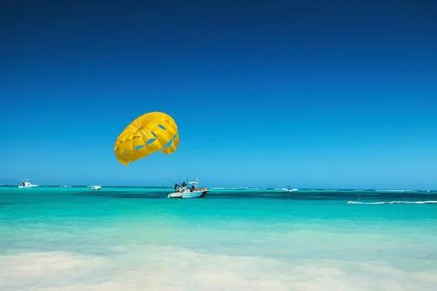 Yellow Parasail Over Tropical Beach With Boat and Blue Sky caribbean vacation Фото